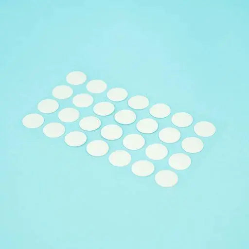 A sheet of Welsh white Dethleffs self-adhesive dot stickers on a transparent backing.