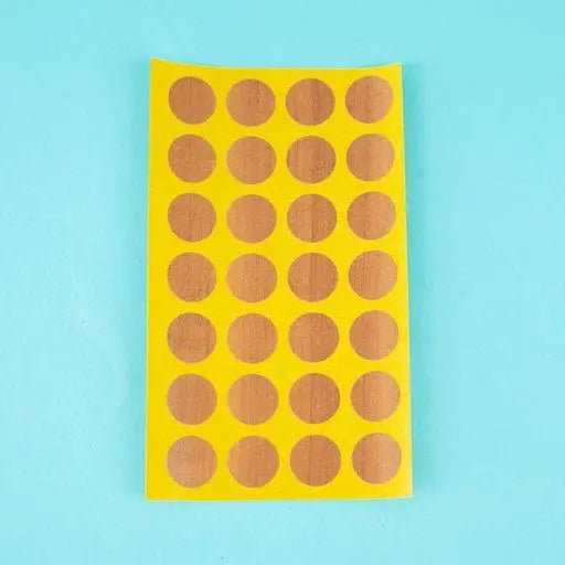 A sheet of topaz apfel / cypress villa Dethleffs self-adhesive dot stickers on a yellow backing.
