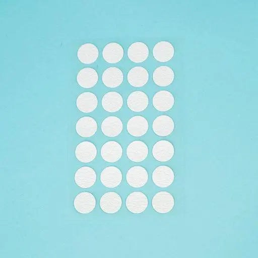 A sheet of Welsh white Dethleffs self-adhesive dot stickers on a transparent backing.