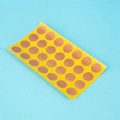 A sheet of topaz apfel / cypress villa Dethleffs self-adhesive dot stickers on a yellow backing.
