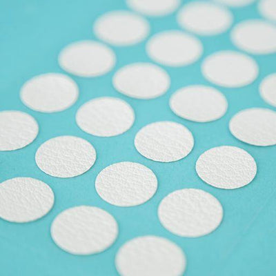 A sheet of Welsh white Dethleffs self-adhesive dot stickers on a transparent backing.
