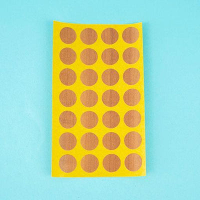 A sheet of topaz apfel / cypress villa Dethleffs self-adhesive dot stickers on a yellow backing.