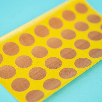 A sheet of topaz apfel / cypress villa Dethleffs self-adhesive dot stickers on a yellow backing.