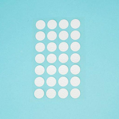 A sheet of Welsh white Dethleffs self-adhesive dot stickers on a transparent backing.